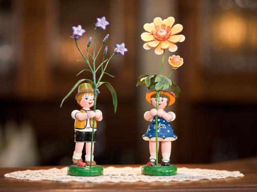 two figurines of two people with flowers on a table at Landhotel Zum Hammer in Tannenberg