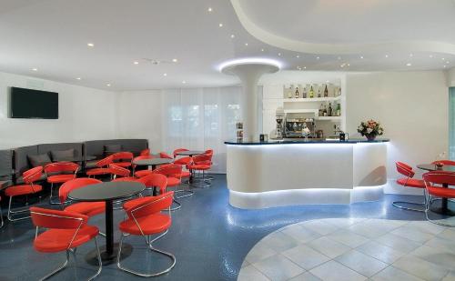 a waiting room with red chairs and a counter at Hotel Majestic in Gabicce Mare