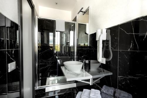 a black bathroom with a sink and a mirror at B&B Notti d'Oriente in Sutri