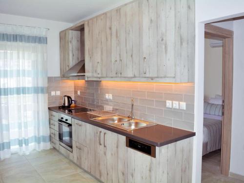 a kitchen with wooden cabinets and a sink at Beach House in Plakias