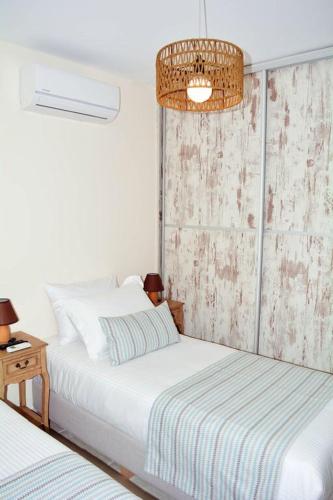 a bedroom with two beds and a chandelier at Beach House in Plakias