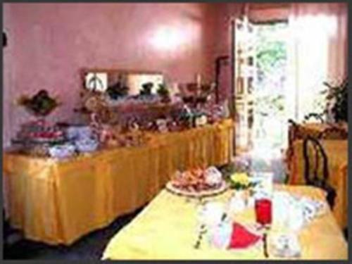 Hotel Moderno في ريميني: مجموعة طاولات في غرفة عليها طعام