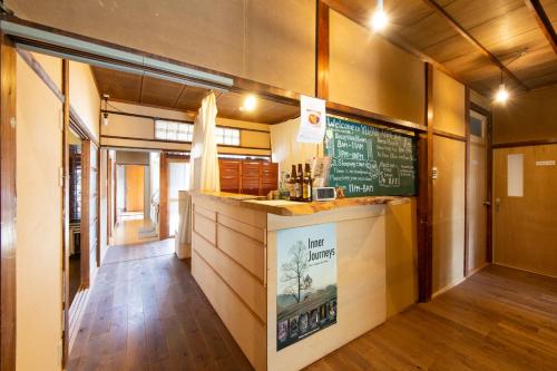een restaurant met een bar en een schoolbord aan de muur bij Yuzan Guesthouse in Nara