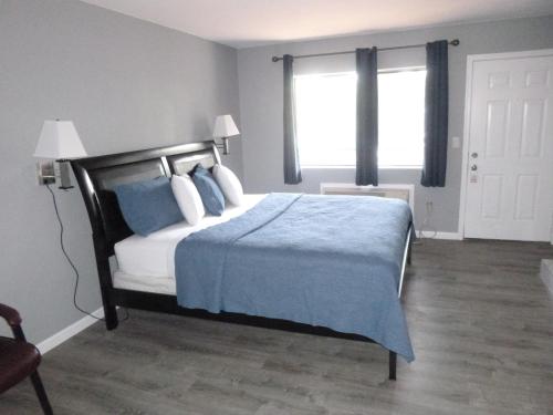 una camera da letto con un letto con cuscini blu e una finestra di Sierra Inn a Prescott