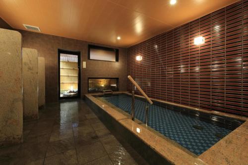 a swimming pool in a building with a fireplace at Hotel Kuu Kyoto in Kyoto