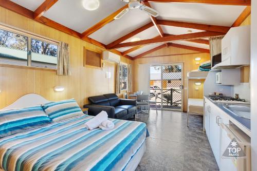 a bedroom with a bed and a living room at Boomerang Way Tourist Park in Tocumwal