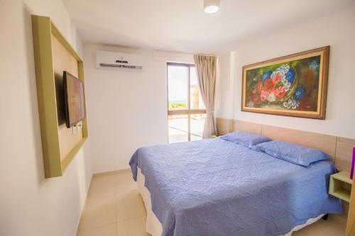 Un dormitorio con una cama azul y una pintura en la pared en Eco Summer Flat Tambaú, en João Pessoa
