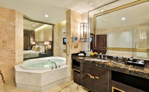 uma casa de banho com uma banheira e um espelho grande em InterContinental Sancha Lake, an IHG Hotel em Chengdu