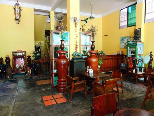 un restaurante con mesas de madera y sillas en una habitación en Star Wood Inn en Phnom Penh