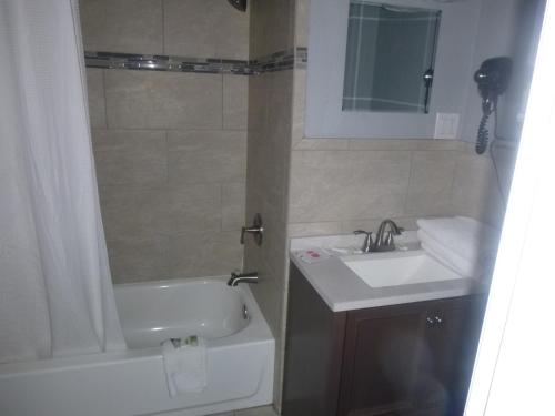 a bathroom with a sink and a tub and a toilet at Sierra Inn in Prescott