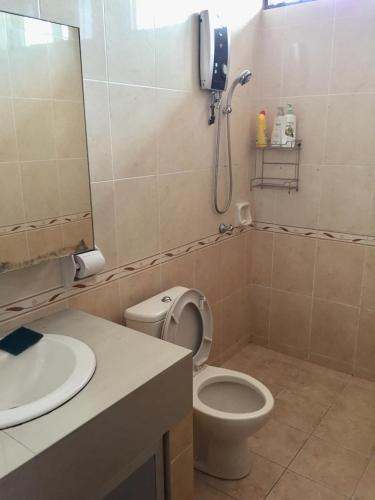 a bathroom with a toilet and a sink and a shower at The oasis in Kuching
