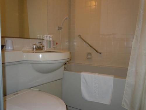 a bathroom with a toilet and a sink and a tub at Aizuwakamatsu Washington Hotel in Aizuwakamatsu