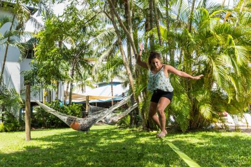 a woman swinging on a hammock in a yard at Summer House Cairns in Cairns