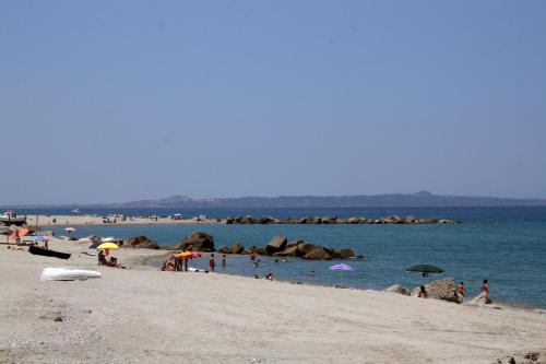 a group of people on a beach with umbrellas at Splash's Rooms in Spadafora