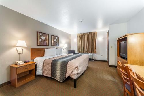 a hotel room with a bed and a television at Welcome Suites-O'Fallon in O'Fallon