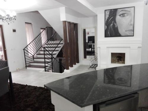 a living room with a staircase and a fireplace at Pensiunea Timiș in Borşa