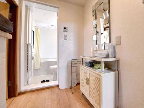 bagno con servizi igienici, lavandino e specchio di Ryokan Niko a Koganei