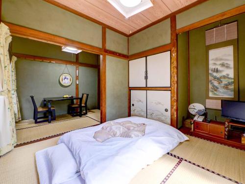 a bedroom with a bed and a table in it at Ryokan Niko in Koganei