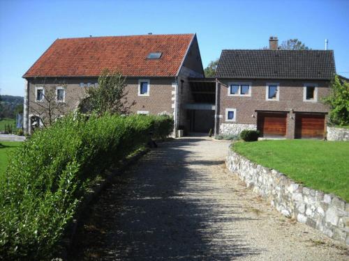uma grande casa de tijolos com uma estrada que o leva em Quaint Holiday Home in Limbourg with Garden em Hèvremont