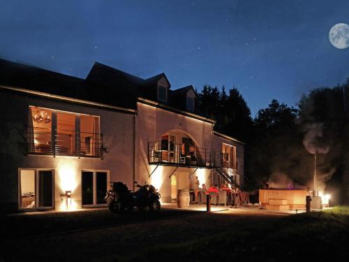 une maison avec deux motos garées devant elle la nuit dans l'établissement Luxurious Villa in Houffalize with Sauna, à Wibrin