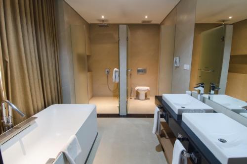 a bathroom with two sinks and a toilet at Megaland Hotel Solo in Solo