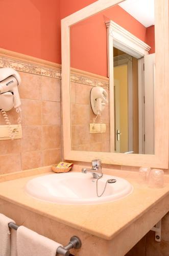 a bathroom with a sink and a mirror at Apartamentos Piedramar in Conil de la Frontera