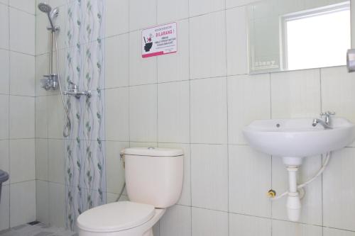 a bathroom with a toilet and a sink at RedDoorz Syariah near Balai Kota Probolinggo 2 in Probolinggo
