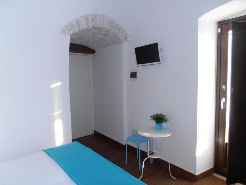 Habitación con cama, mesa y TV. en Masseria Nonna Angela, en Putignano