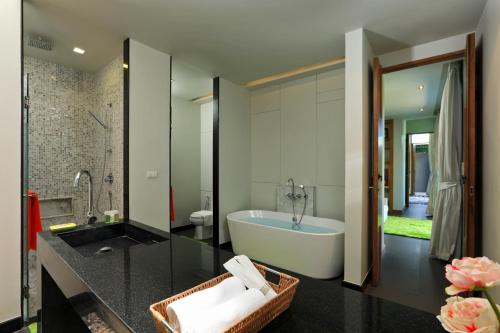 a bathroom with a bath tub and a sink at 3BDR Pool villa at Bangtao Wings #45 in Bang Tao Beach