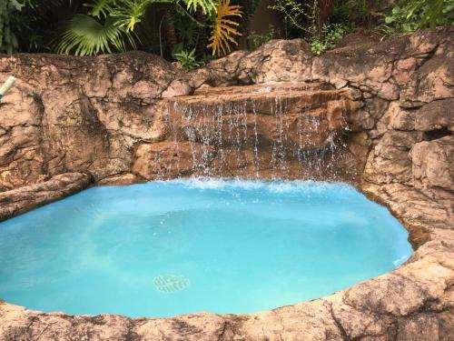 a large pool with a waterfall in a stone wall at Tranquility in Margate