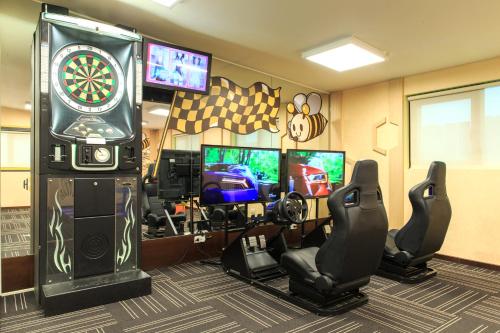ein Spielezimmer mit einer Dartscheibe und mehreren TVs in der Unterkunft Bee House by Cosmos Creation - Taipei Main Station in Taipeh