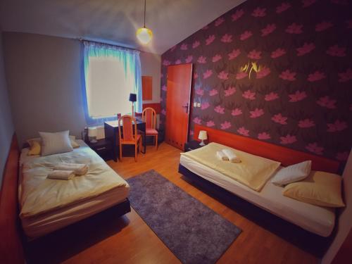 - une chambre avec deux lits, une table et une chaise dans l'établissement Hotel Komfort Inn - Dwór Hubertus, à Piekary Śląskie