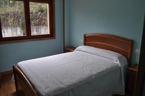 Schlafzimmer mit einem Bett und einem Fenster in der Unterkunft PISO MARENTES in O Grove