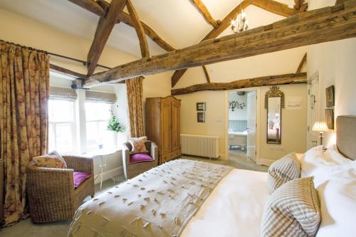 a master bedroom with a large bed and wooden ceilings at The Punch Bowl Inn in Kendal