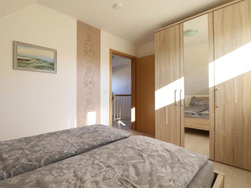 ヴィーク・アウフ・リューゲンにあるModern Holiday Home in Wiek with Gardenのベッドルーム1室(ベッド1台付)、木製キャビネットが備わります。