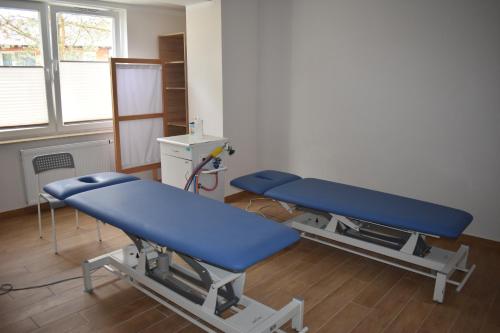 a hospital room with two blue beds in it at Hotel *** NAT Jarosławiec in Jarosławiec