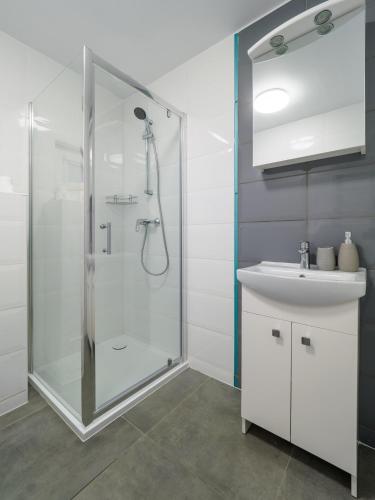 a bathroom with a shower and a sink at Parkova Apartamenty in Międzywodzie
