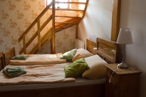 two twin beds in a room with a staircase at Statek Chmelovice in Chmelovice