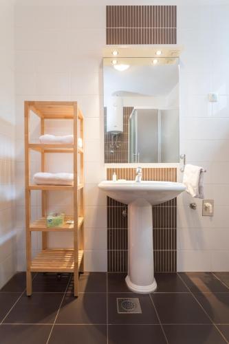 a bathroom with a sink and a shelf with towels at Apartments Jadranka in Selce