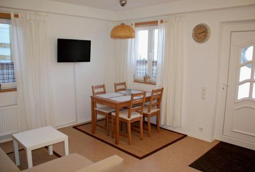 a dining room with a table and chairs and a tv at Ferienwohnung Gipfelstürmer in Bolsterlang