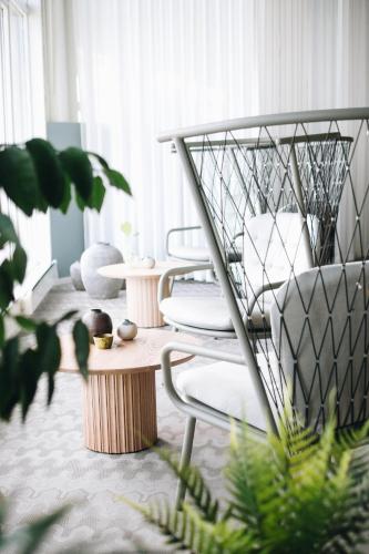 a living room with white chairs and a table at Hotell Södra Berget in Sundsvall