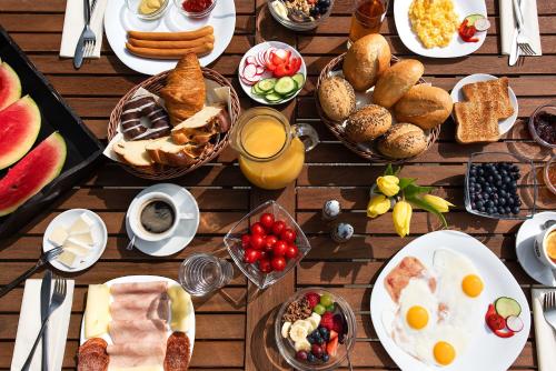 a wooden table topped with breakfast foods and drinks at Penzion Baltazar Mikulov in Mikulov