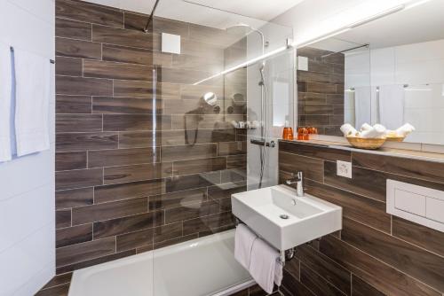 a bathroom with a sink and a shower at Central Sporthotel Davos in Davos