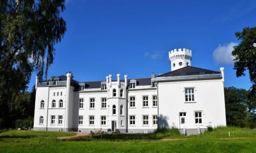 a large white building with a tower on top at Schloss Hohendorf in Groß Mohrdorf