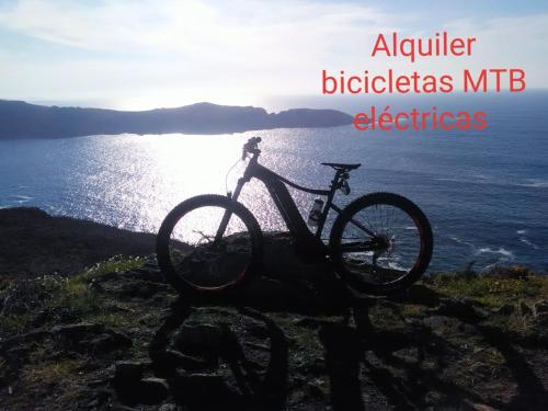 a bike parked on the side of a hill next to the ocean at Hostal Meson Leira Antiga in Cedeira