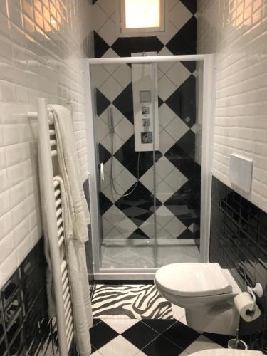 a black and white bathroom with a toilet and a shower at Camaldoli House in Milan