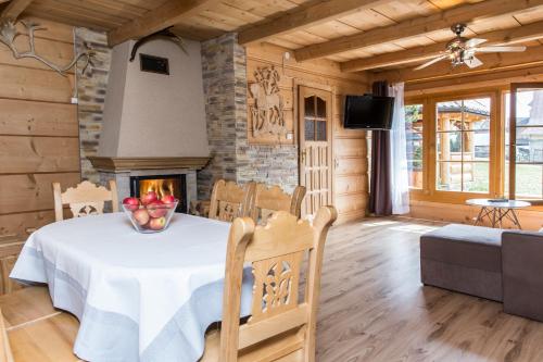 a dining room with a table and a fireplace at udanypobyt Domek Przy Lesie in Kościelisko