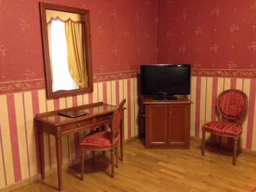 a room with a desk with a television and two chairs at Hotel Holiday Sul Lago in Bolsena
