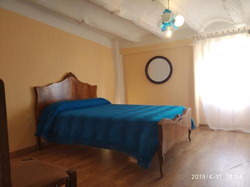 a bedroom with a bed with a blue blanket at Hispanoconcucense in Teruel