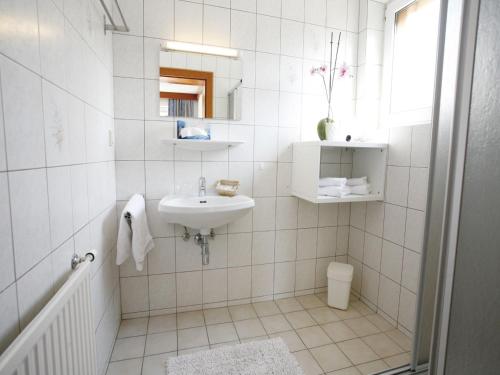 a white bathroom with a sink and a mirror at Pension Christiane in Sankt Kanzian